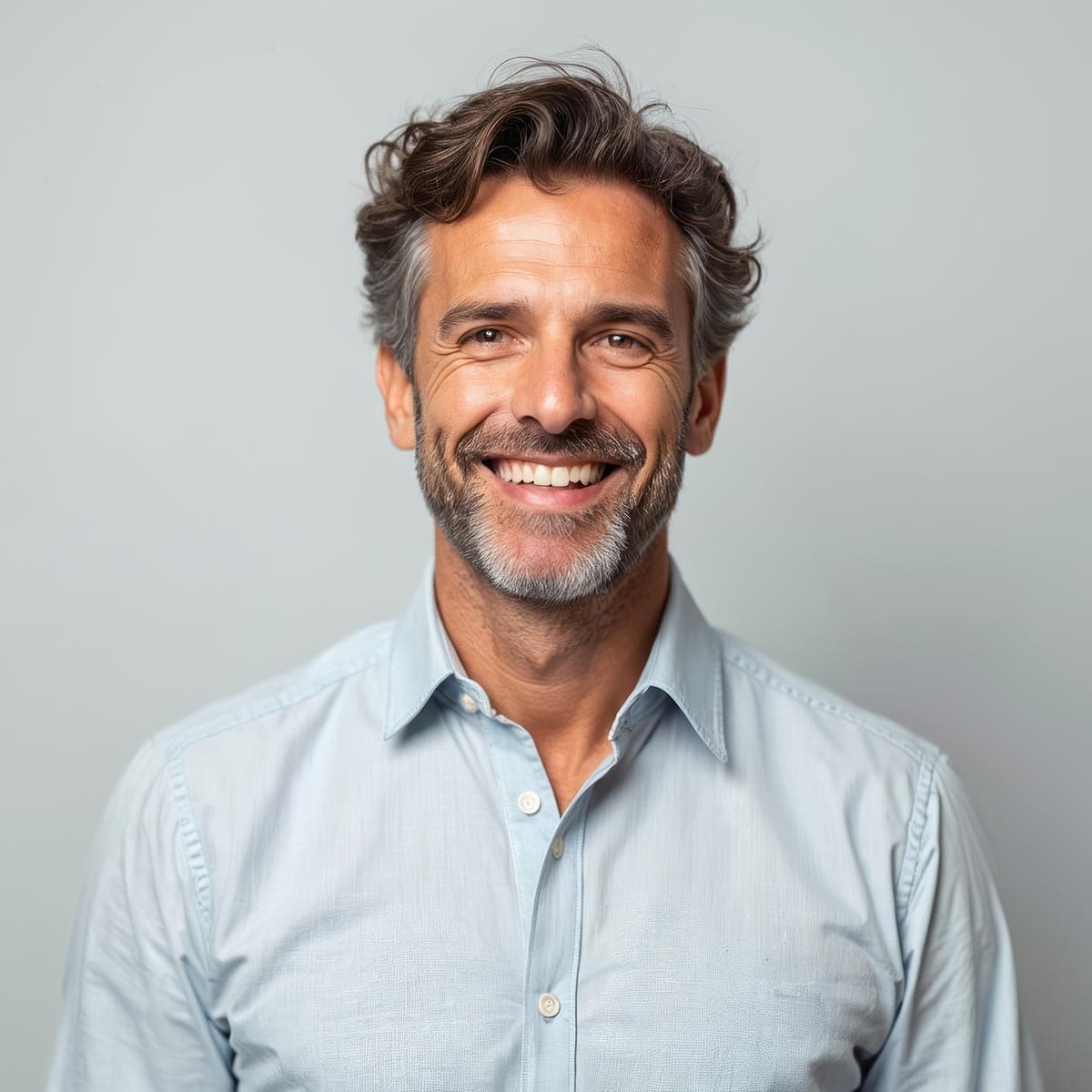 Smiling man showing healthy teeth after dental crowns and bridges treatment