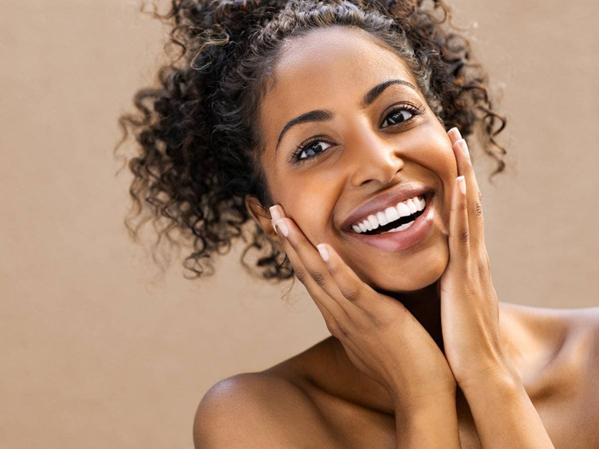 Woman smiling confidently after dental crown or bridge restoration treatment